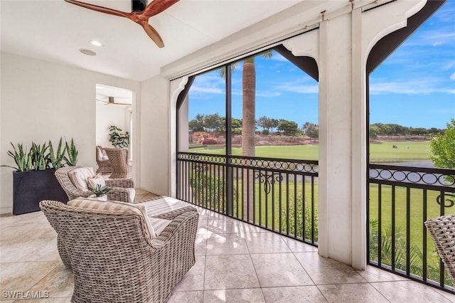 sunroom / solarium featuring a ceiling fan