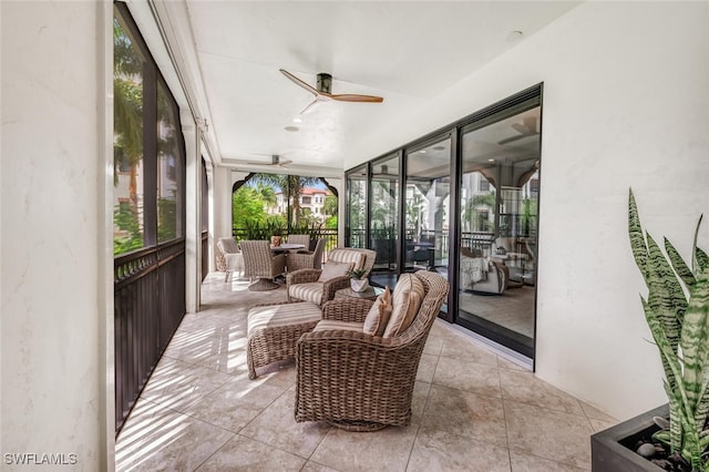 sunroom featuring ceiling fan and tile patterned flooring