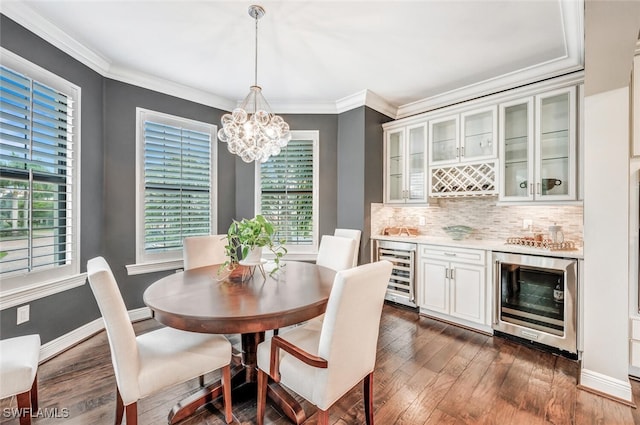 dining space featuring a chandelier, beverage cooler, crown molding, and dark wood-style flooring
