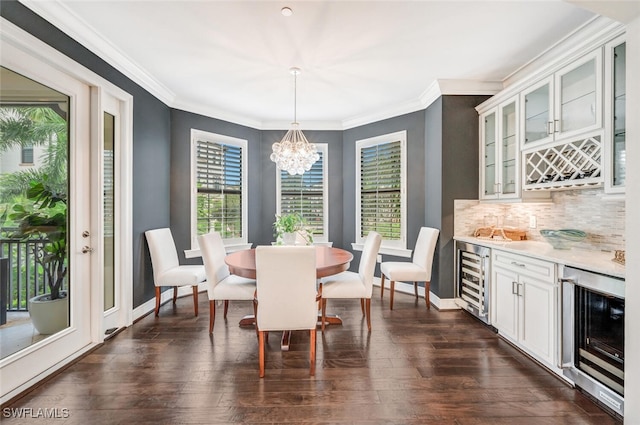 dining room featuring dark wood-type flooring, beverage cooler, crown molding, and a bar