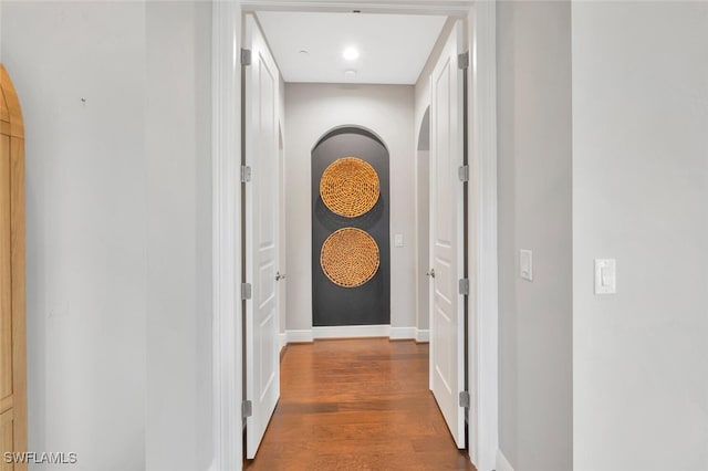 hall with baseboards and wood finished floors