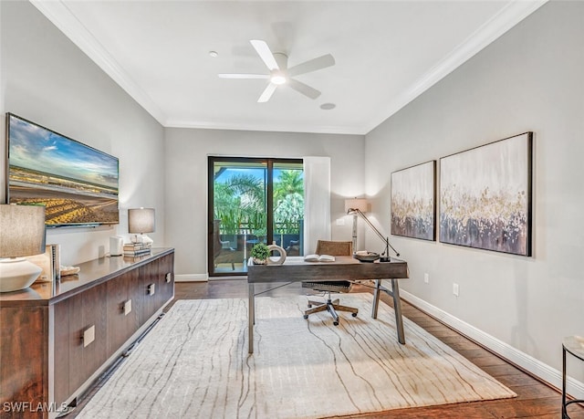 office area featuring crown molding, baseboards, a ceiling fan, and wood finished floors