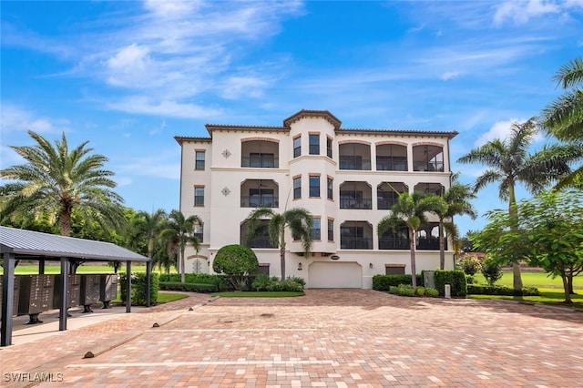 view of property featuring a garage and decorative driveway