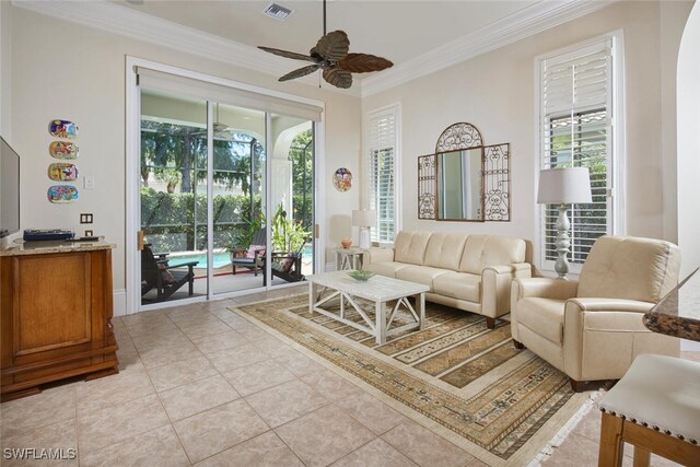 living room featuring ceiling fan, a healthy amount of sunlight, light tile patterned floors, and crown molding