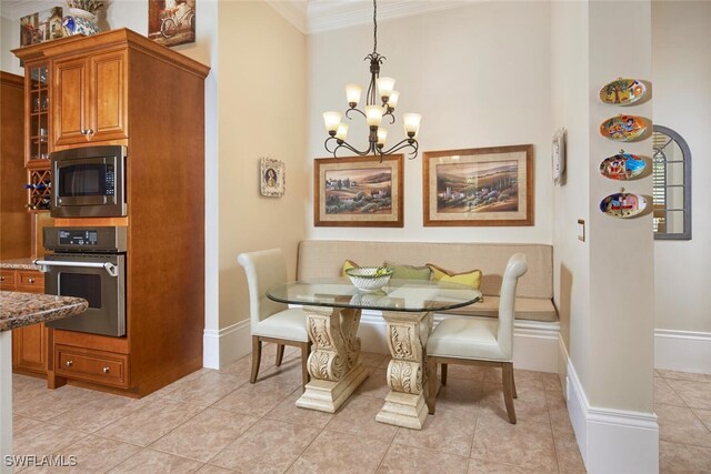 dining area with ornamental molding, light tile patterned floors, and an inviting chandelier