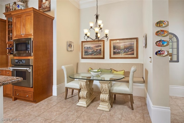 dining space featuring light tile patterned floors, crown molding, baseboards, breakfast area, and an inviting chandelier