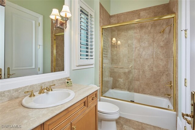 bathroom featuring shower / bath combination with glass door, vanity, toilet, and tile patterned floors