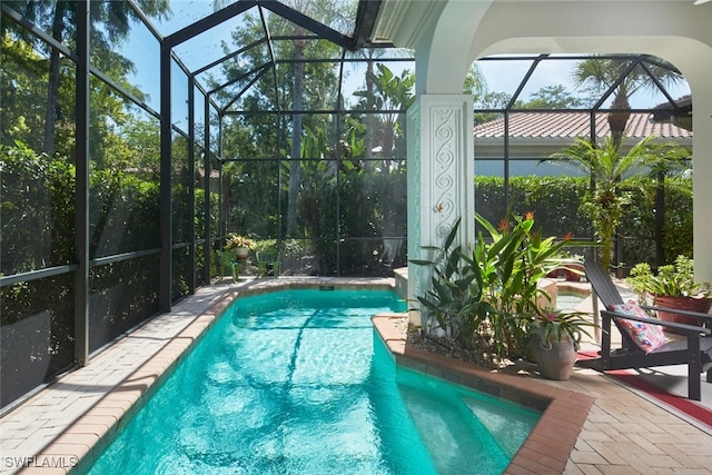 view of swimming pool with glass enclosure and a patio area