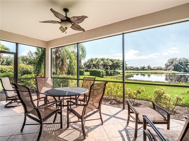 sunroom / solarium with ceiling fan and a water view