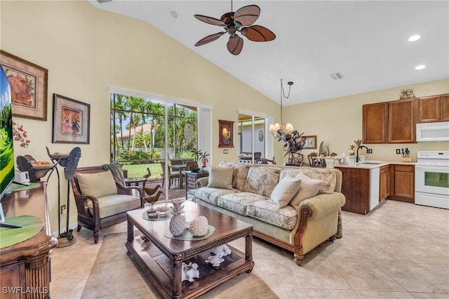 living room featuring sink, high vaulted ceiling, light tile patterned flooring, and ceiling fan with notable chandelier