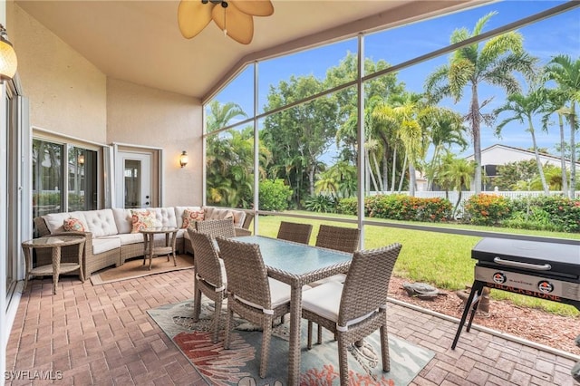 sunroom / solarium with ceiling fan and lofted ceiling