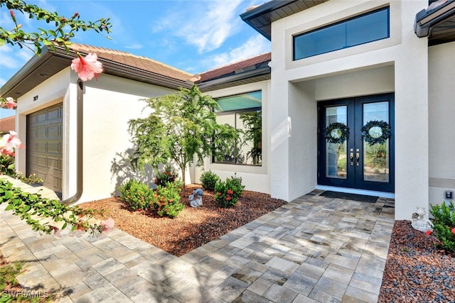 doorway to property with a garage and french doors