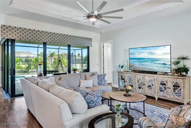 living area featuring ornamental molding, a raised ceiling, and wood finished floors