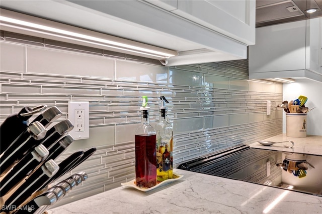 kitchen featuring tasteful backsplash and light stone counters