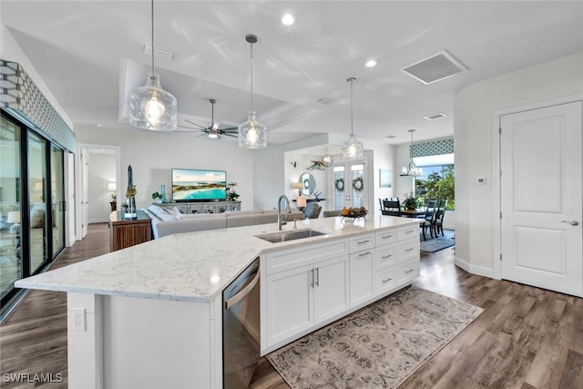 kitchen with visible vents, open floor plan, a sink, an island with sink, and dishwasher