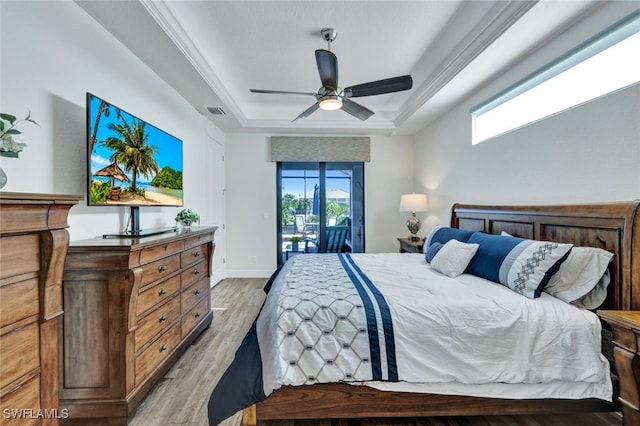 bedroom featuring visible vents, baseboards, access to exterior, light wood-type flooring, and a tray ceiling