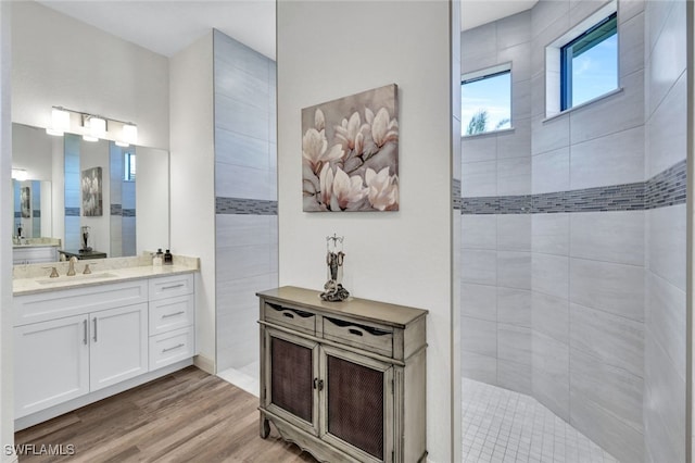 bathroom with a walk in shower, vanity, and wood finished floors