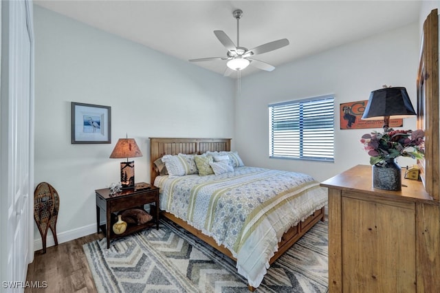 bedroom with light wood finished floors, a ceiling fan, and baseboards