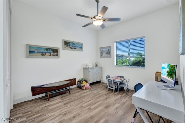 home office featuring light wood-type flooring, ceiling fan, and baseboards