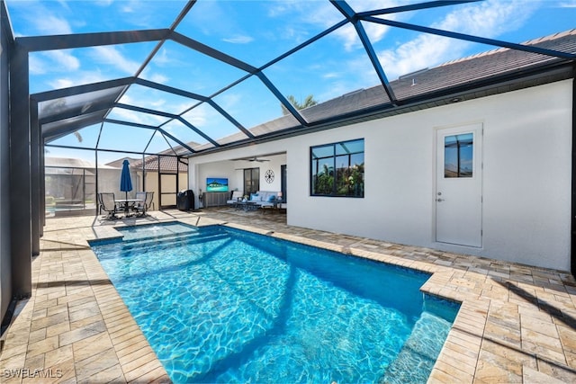 outdoor pool with a ceiling fan, a lanai, a patio, and an outdoor living space