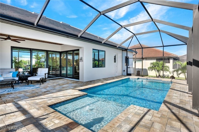 outdoor pool with a ceiling fan, glass enclosure, and a patio area