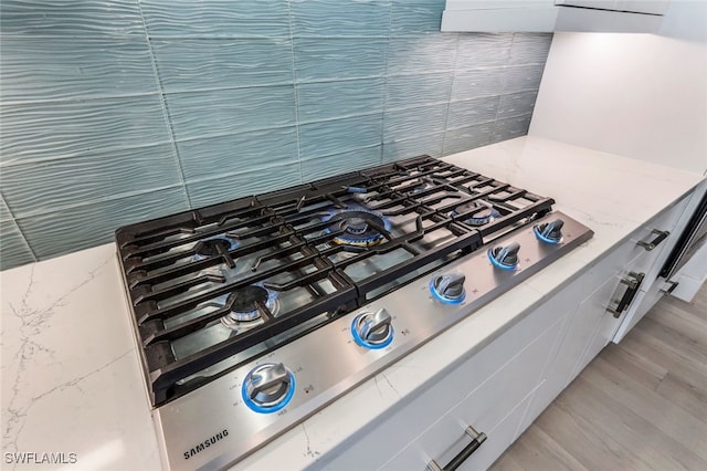 interior details with stainless steel gas stovetop and light hardwood / wood-style floors