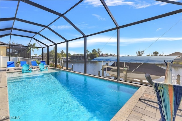 view of pool featuring glass enclosure, a patio area, and a water view