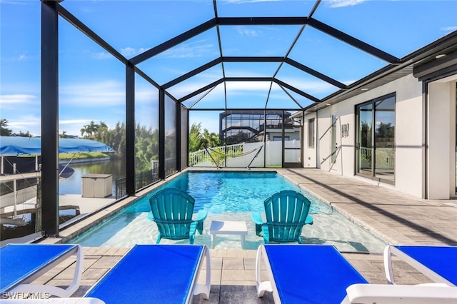 view of swimming pool featuring glass enclosure, a water view, and a patio