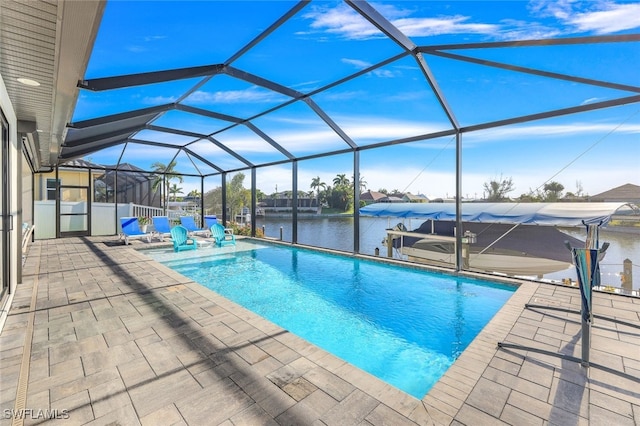 view of swimming pool with glass enclosure, a patio area, and a water view