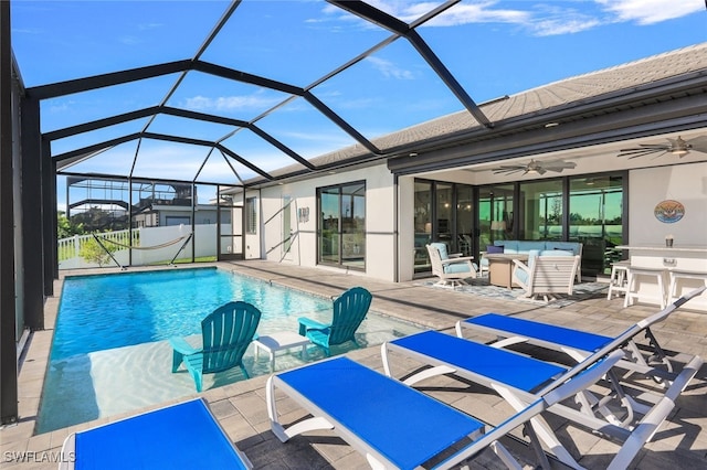 view of pool featuring glass enclosure, ceiling fan, and a patio