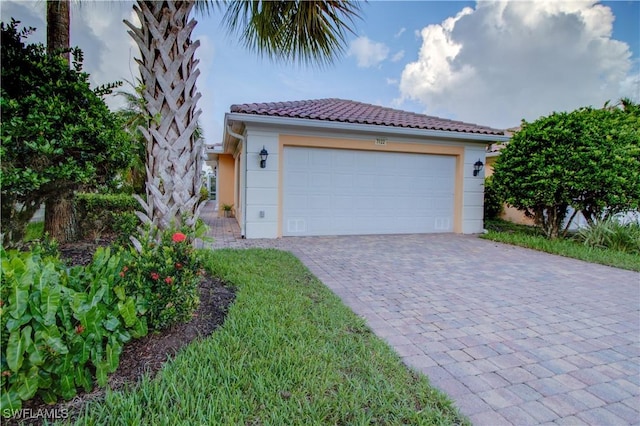 view of front of home featuring a garage, a tile roof, and stucco siding