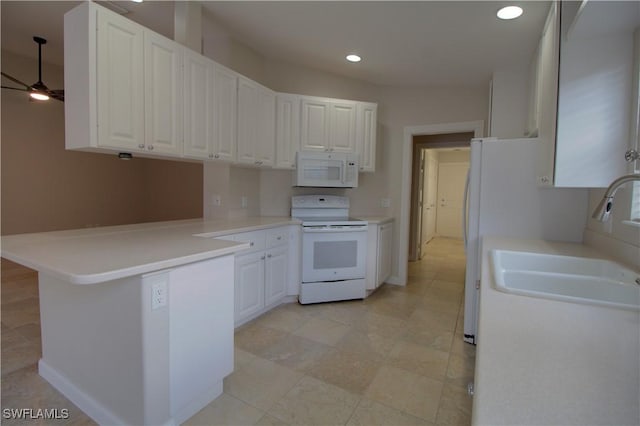 kitchen with a peninsula, white appliances, white cabinetry, and a sink