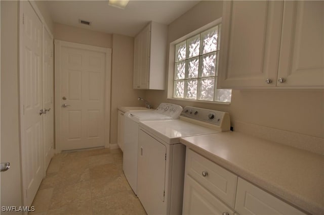 laundry area featuring visible vents, a sink, cabinet space, and washer and dryer