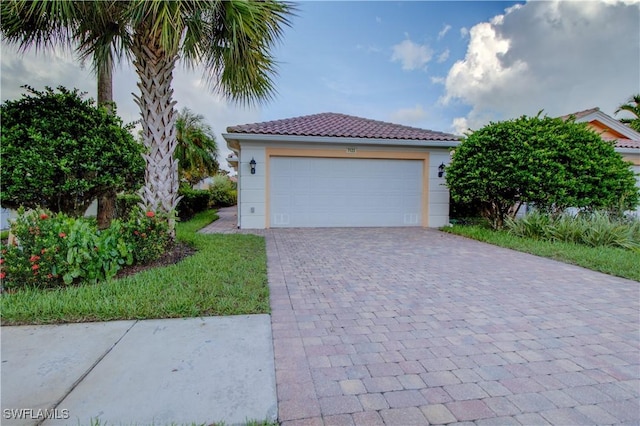 view of front of home featuring a garage, a tiled roof, and stucco siding