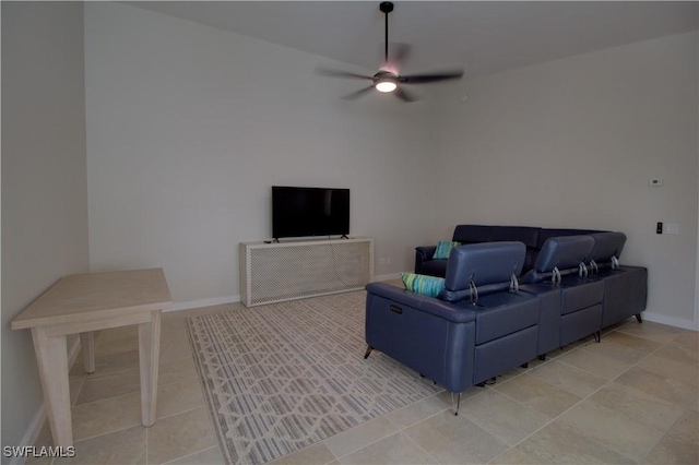 living area with a ceiling fan and baseboards