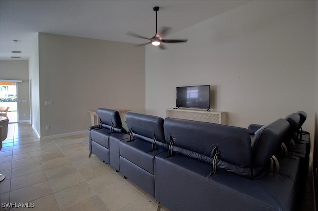 home theater room with light tile patterned floors, a ceiling fan, and baseboards