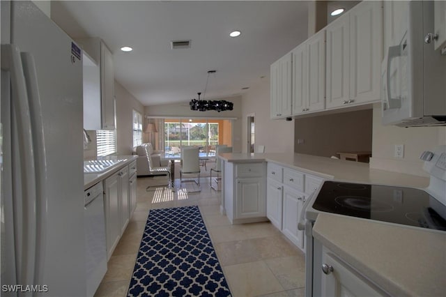 kitchen featuring lofted ceiling, visible vents, white cabinetry, white appliances, and a peninsula