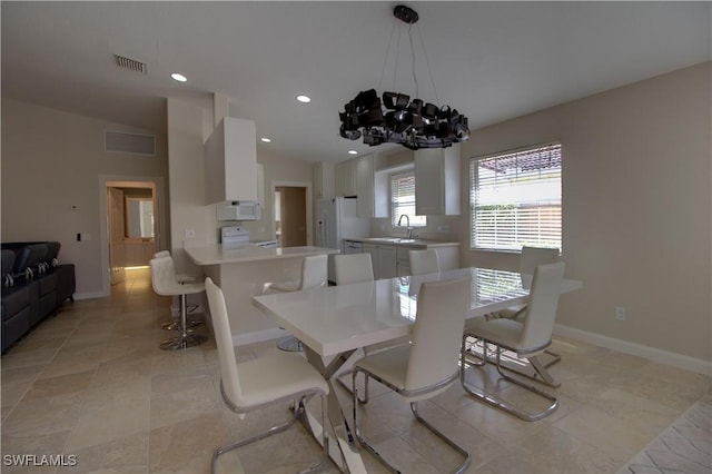 dining space with visible vents, baseboards, lofted ceiling, a notable chandelier, and recessed lighting