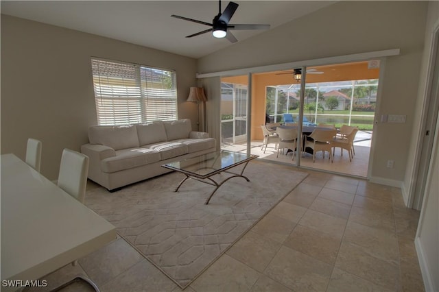 living area with lofted ceiling, tile patterned flooring, a healthy amount of sunlight, and baseboards