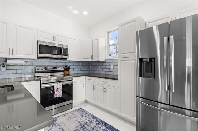 kitchen with white cabinets, appliances with stainless steel finishes, decorative backsplash, and sink