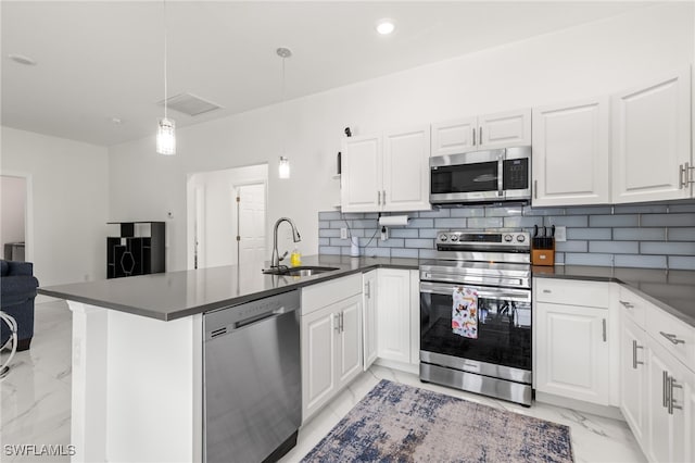 kitchen featuring kitchen peninsula, decorative light fixtures, and appliances with stainless steel finishes