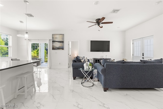 living room with ceiling fan and french doors