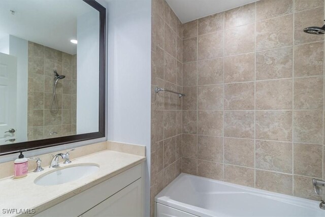 bathroom featuring tiled shower / bath combo and vanity