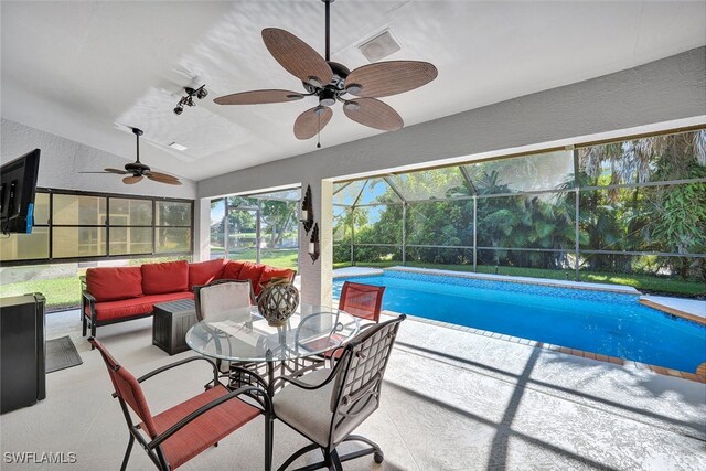 view of swimming pool with ceiling fan, an outdoor living space, glass enclosure, and a patio