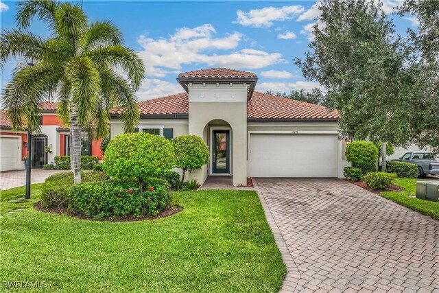 mediterranean / spanish-style home with a garage and a front lawn