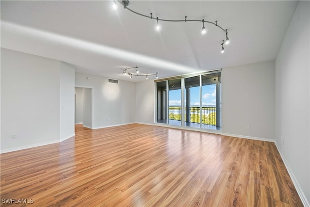 spare room with track lighting and light wood-type flooring