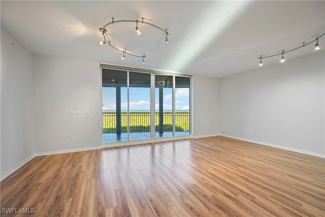 unfurnished room with expansive windows and wood-type flooring