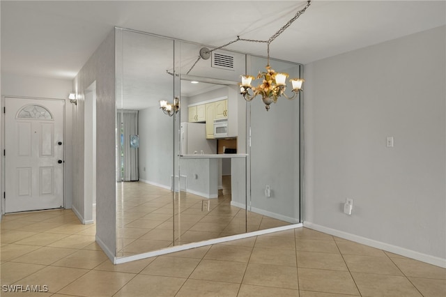 unfurnished dining area featuring light tile patterned floors, visible vents, a chandelier, and baseboards