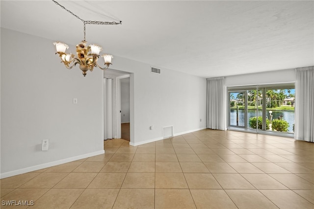 unfurnished room featuring a water view, light tile patterned floors, visible vents, and a chandelier