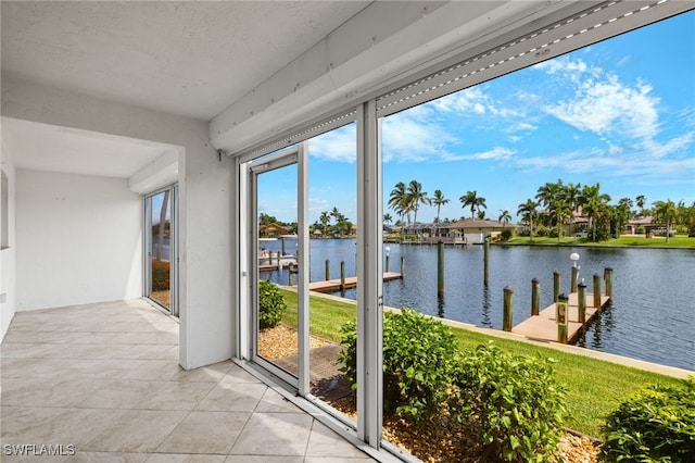 sunroom featuring a water view